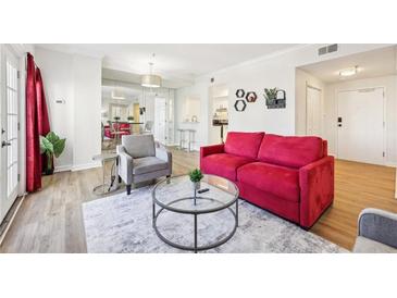 Bright living room with a red couch, armchair, and glass coffee table, filled with natural light at 2161 Peachtree Ne Rd # 405, Atlanta, GA 30309