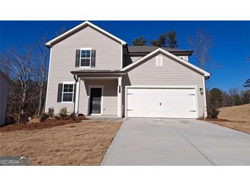 Charming two-story home featuring a light gray exterior, a two-car garage, and a well-maintained front yard at 8516 Polston Place Dr, Douglasville, GA 30134