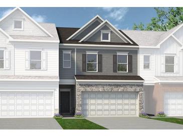 Charming townhouse showcasing a stone facade, two-car garage, and neutral gray tones at 2565 Ravencliff Dr # 74, Austell, GA 30168