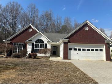 Charming single-story home featuring a brick facade, attached garage, and well-maintained landscaping at 275 Circle Rd, Dacula, GA 30019