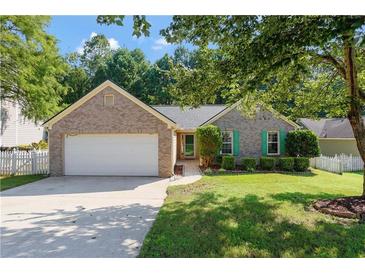 Charming brick home with attached garage, manicured lawn, and cute green shutters at 5745 River Ridge Ln, Sugar Hill, GA 30518