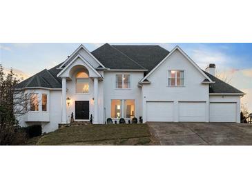 Stately white home featuring a manicured lawn, two-car garage, elegant columns, and a well-maintained landscape at 4349 Highborne Ne Dr, Marietta, GA 30066