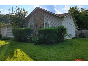 Charming single-Gathering home featuring a stone facade and well-maintained lawn with mature landscaping and lots of shade at 4906 Kellys Mill Nw Dr, Lilburn, GA 30047