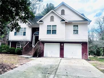 Charming two-story home featuring a two-car garage, landscaped yard, and a welcoming front entrance at 4415 Yates Rd, Atlanta, GA 30337