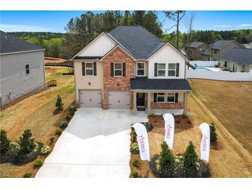 Charming two-story home featuring brick and siding, complemented by a well-manicured lawn at 1645 Fuma Leaf Way, Mcdonough, GA 30253
