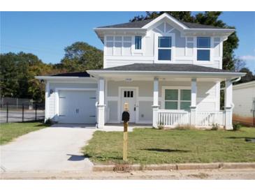 Charming two-story home with a front porch, attached garage, and newly installed driveway in a quiet neighborhood at 2414 Rose Palm Pl, Atlanta, GA 30315