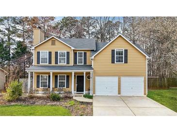 Two-story home boasts a welcoming porch, symmetrical windows with shutters, and attached two-car garage at 4831 Lake Park Ter, Acworth, GA 30101