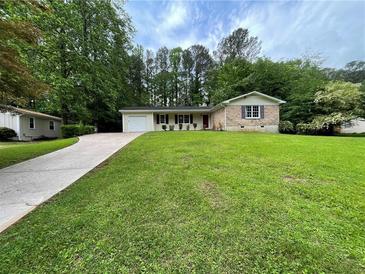 Charming single-story home with a well-manicured lawn, lovely landscaping and a long driveway at 371 Landers Sw Dr, Mableton, GA 30126