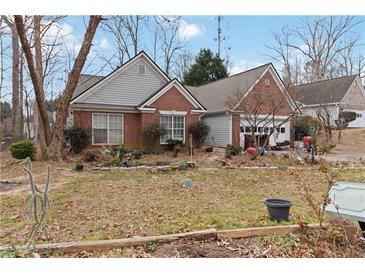 Charming single-story home featuring a brick facade, attached garage, and a well-maintained front yard at 1220 Tab Roberts Rd, Lawrenceville, GA 30043