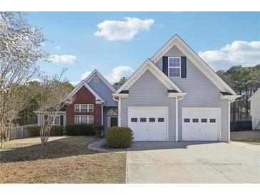 Charming home featuring a two-car garage, beautiful landscaping, and a mix of brick and siding exterior at 1925 Meyers Dr, Lawrenceville, GA 30045