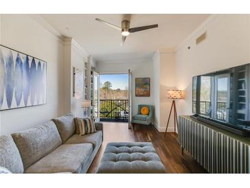 Bright living room featuring a cozy sofa, balcony access, hardwood floors, and stylish decor at 2277 Peachtree Ne Rd # 608, Atlanta, GA 30309