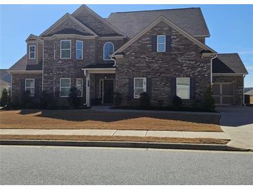 Charming two-story brick home with lush landscaping and a welcoming front entrance at 3671 Casual Ridge Way, Loganville, GA 30052