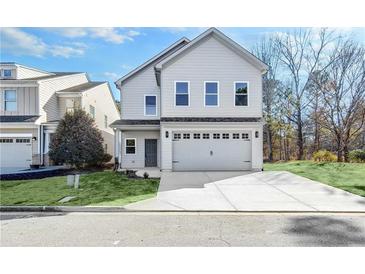 Charming two-story home with a two-car garage and well-maintained lawn at 7608 Parkland Bnd, Fairburn, GA 30213
