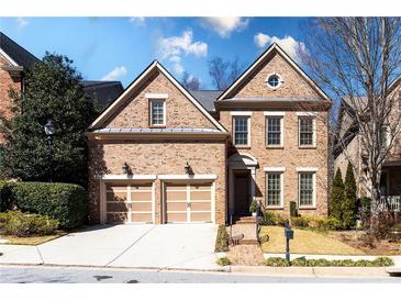 Charming brick home featuring a two-car garage, manicured lawn, and classic architectural details at 1837 Haven Park Se Cir, Smyrna, GA 30080