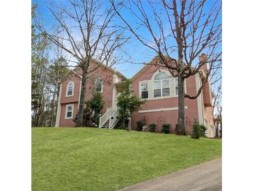 Charming two-story pink home with a well-manicured lawn and inviting front entrance at 610 Coolsprings Ln, Woodstock, GA 30188