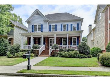 Charming two-story home featuring a welcoming front porch, blue shutters, and well-manicured landscaping at 2110 Se Murren Se Dr, Smyrna, GA 30080