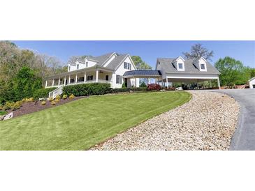 Inviting white home with a charming front porch and well-manicured lawn at 281 Chilhoe Dr, Canton, GA 30115