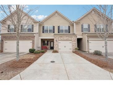 Charming townhome featuring a one car garage and inviting brick and siding exterior at 2785 Maple Park Pl, Cumming, GA 30041
