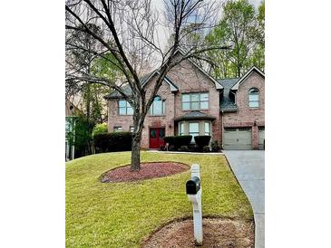 Charming two-story brick home with a well-manicured lawn and mature trees at 709 Eastwood Rise, Stone Mountain, GA 30087