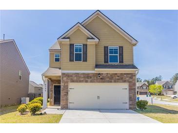 Charming two-story home showcasing a stone facade, attached garage, and a well-maintained front yard in a suburban neighborhood at 6399 Woodwell Dr, Union City, GA 30291