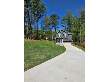 New two-story home featuring a 2-car garage and inviting front porch, all nestled on a well-manicured lawn at 113 Miller Rd, Stockbridge, GA 30281