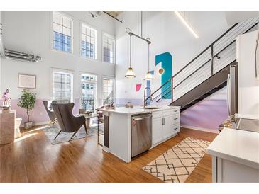 Bright living room features an open layout, modern kitchen island, high ceilings, and large windows for natural light at 260 18Th Nw St # 10202, Atlanta, GA 30363