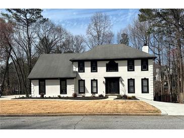 Charming two-story home features a classic white exterior with dark trim and a well-manicured lawn at 4960 Trevino Cir, Duluth, GA 30096