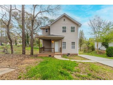 Charming two-story home with a front porch, driveway, and natural landscaping, perfect for suburban living at 202 Nathan Sw Rd, Atlanta, GA 30331