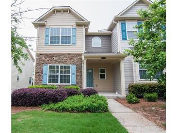 Charming home featuring a stone facade and a well-manicured lawn with lush landscaping at 2453 Suwanee Pointe Dr, Lawrenceville, GA 30043