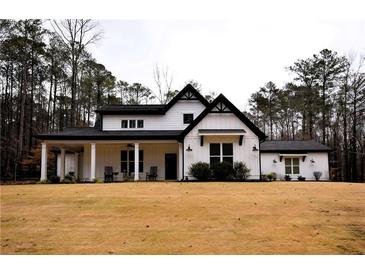 Charming modern farmhouse with a welcoming front porch, black trim, and large front lawn at 3034 South Baggett Rd, Winston, GA 30187