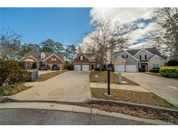 View of homes featuring well-manicured lawns, driveways, and inviting exteriors at 104 Shadow Creek Ct, Fairburn, GA 30213