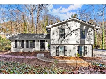 Charming two-story home featuring a neatly maintained yard with a stone walkway leading to the front door at 5916 Simone Dr, Stone Mountain, GA 30087