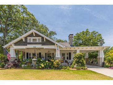 Charming bungalow featuring a landscaped yard, inviting front porch and convenient covered carport at 1000 Nw Main St, Conyers, GA 30012