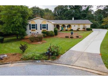 Charming single-Gathering home with manicured lawn, mature trees, and brick and concrete driveway at 3681 Donavan Ct, Decatur, GA 30034