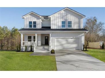 Charming two-story home featuring white siding, a front porch, an attached two car garage, and a well-manicured lawn at 364 Poplar Springs Rd, Hiram, GA 30141