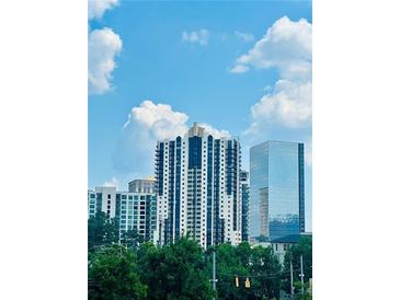 Modern high-rise building with a beautiful blue sky and green trees in the foreground at 3481 Lakeside Ne Dr # 2303, Atlanta, GA 30326