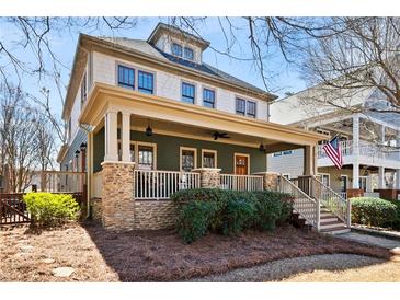 Charming two-story home featuring a welcoming front porch with stone accents and a manicured lawn at 1564 Spring Se St, Smyrna, GA 30080
