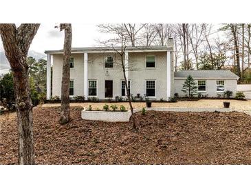 Charming two-story white brick home with a well-maintained front yard and inviting entrance, exuding classic elegance at 800 Glenairy Dr, Atlanta, GA 30328