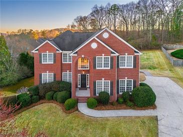 Beautiful two-story brick home with a well-manicured lawn and mature landscaping at 403 Tea Olive Ct, Canton, GA 30115