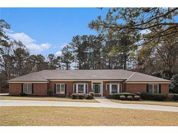 Charming brick home with a well-manicured lawn and mature trees in a desirable neighborhood at 3003 Hanover Se Ln, Conyers, GA 30094