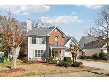 Charming two-story home featuring a mix of brick and siding, complemented by shutters and a landscaped front yard at 1902 Elm Park Dr, Hampton, GA 30228