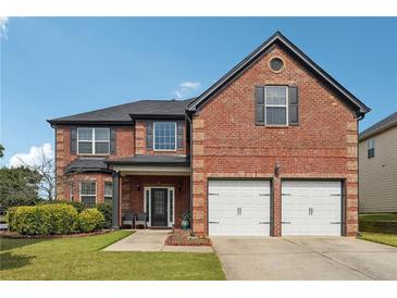 Beautiful two-story brick home with a well-manicured lawn, two-car garage, and classic architectural details at 4205 Idlewood Dr, Cumming, GA 30040