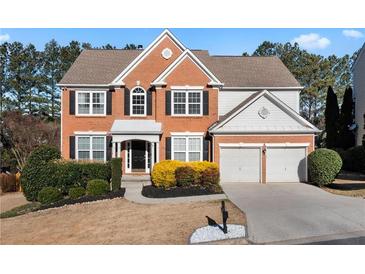 Charming two-story brick home featuring a manicured front yard and attached two-car garage at 3321 Spindletop Nw Dr, Kennesaw, GA 30144