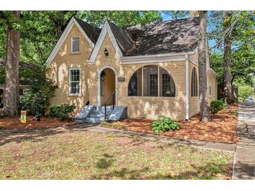 Charming brick home featuring a gabled roof, arched entryway, and well-maintained front yard at 2533 Semmes St, East Point, GA 30344