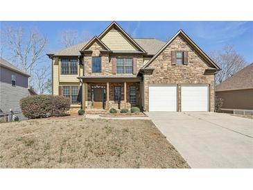 Charming two-story home with a stone and yellow siding exterior and a two-car garage at 70 Wentworth Ln, Villa Rica, GA 30180
