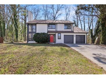 Two-story home with a two-car garage and a landscaped front yard at 1628 Links Overlook, Stone Mountain, GA 30088
