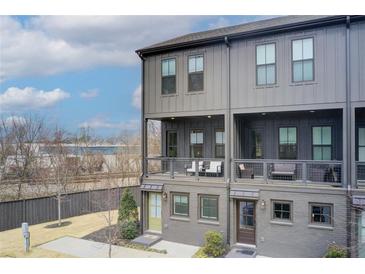 Modern three-story townhouse featuring private balconies and neutral gray brick and siding at 944 Spencer Ave, Atlanta, GA 30318