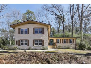 Charming brick home with wood shutters and a well-maintained front yard with mature trees at 3597 Embry Cir, Atlanta, GA 30341