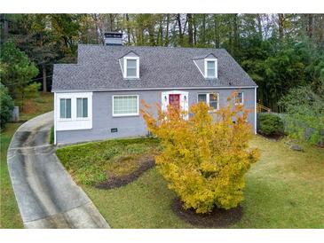 Inviting gray home with dormers and red door, set against a backdrop of autumn foliage at 6596 Wright Rd, Atlanta, GA 30328
