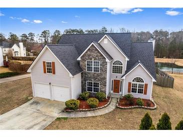 Charming two-story home with stone accents, manicured landscaping, and a two-car garage at 2738 Lakewater Way, Snellville, GA 30039